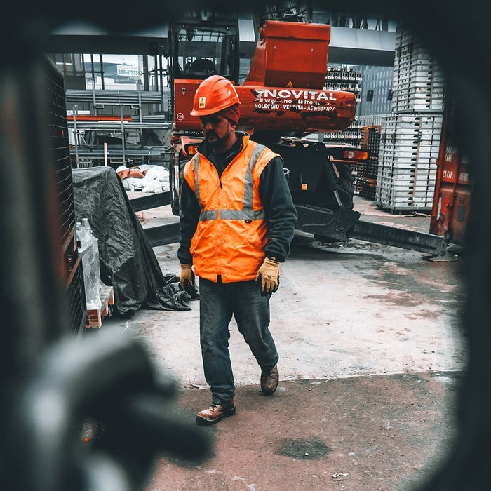 Homme travail dans un chantier, il porte des vêtements de sécurité